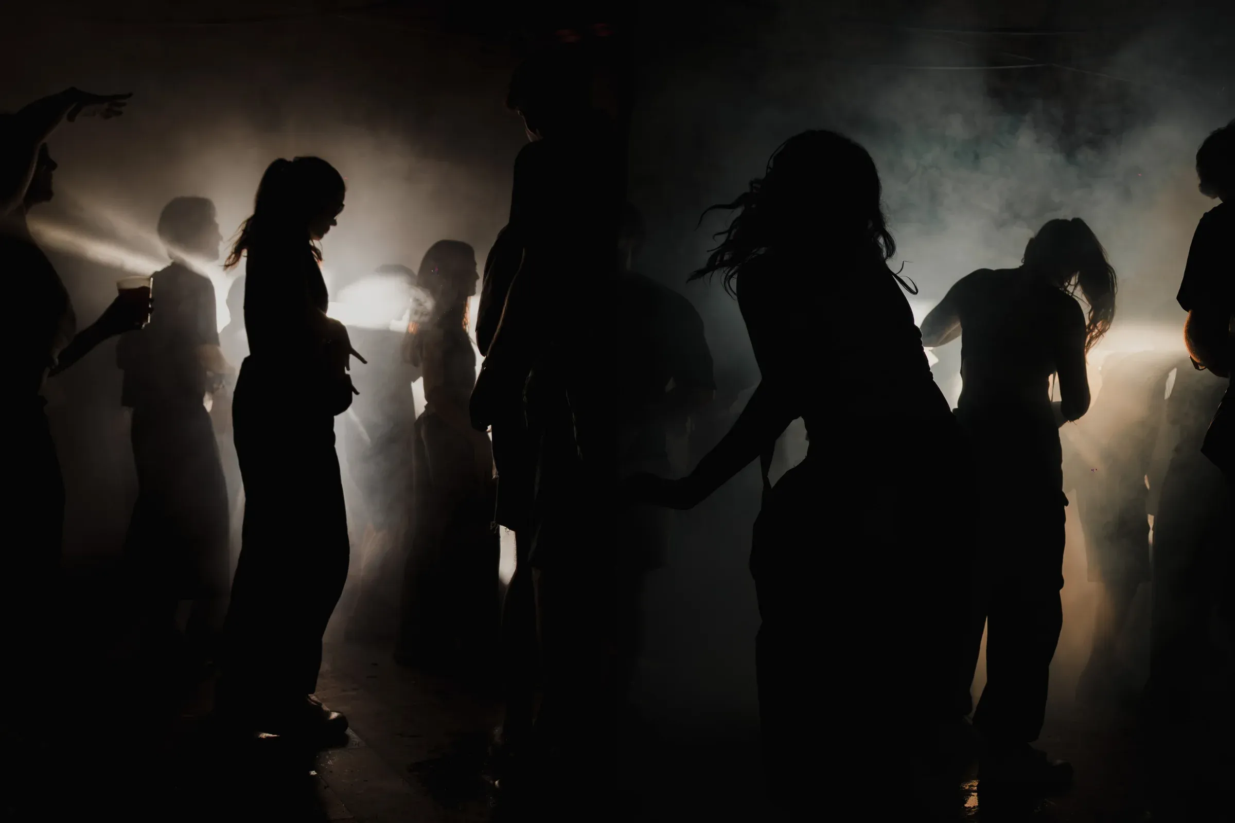 Siluetas bailando entre humo y contraluz